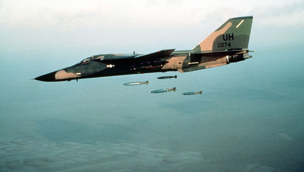 f111e aircraft dropping bombs over a range