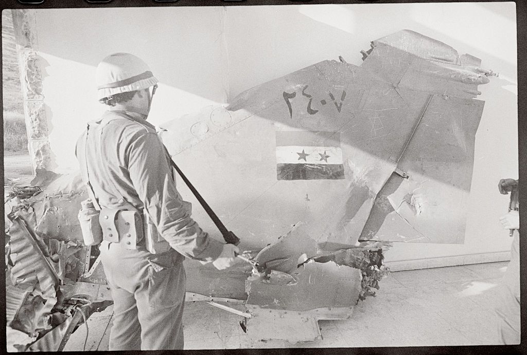 soldier gazing at damaged soviet military jet