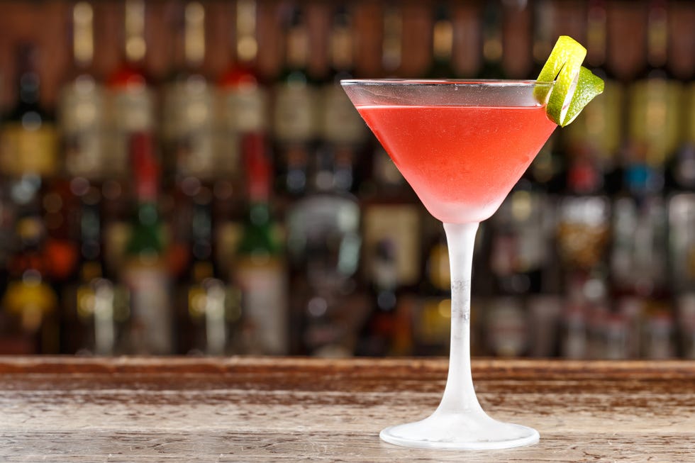 an alcoholic cosmopolitan cocktail is on the bar space for text
