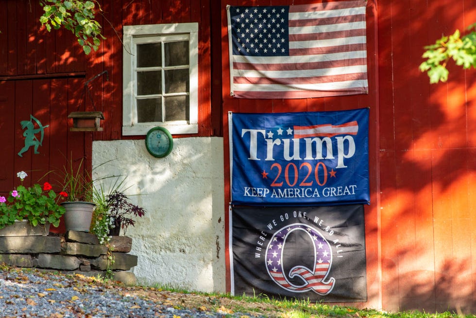 an american flag, a trump re election flag, and a qanon flag