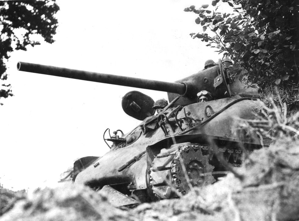 an american sherman m 4 tank awaits the signal to go forward against the germans in the reffuveille area in france