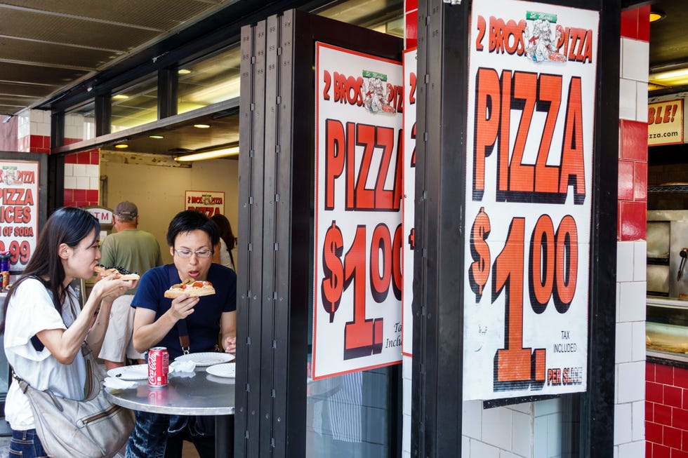 an asian couple eating pizza at 2 bros pizza