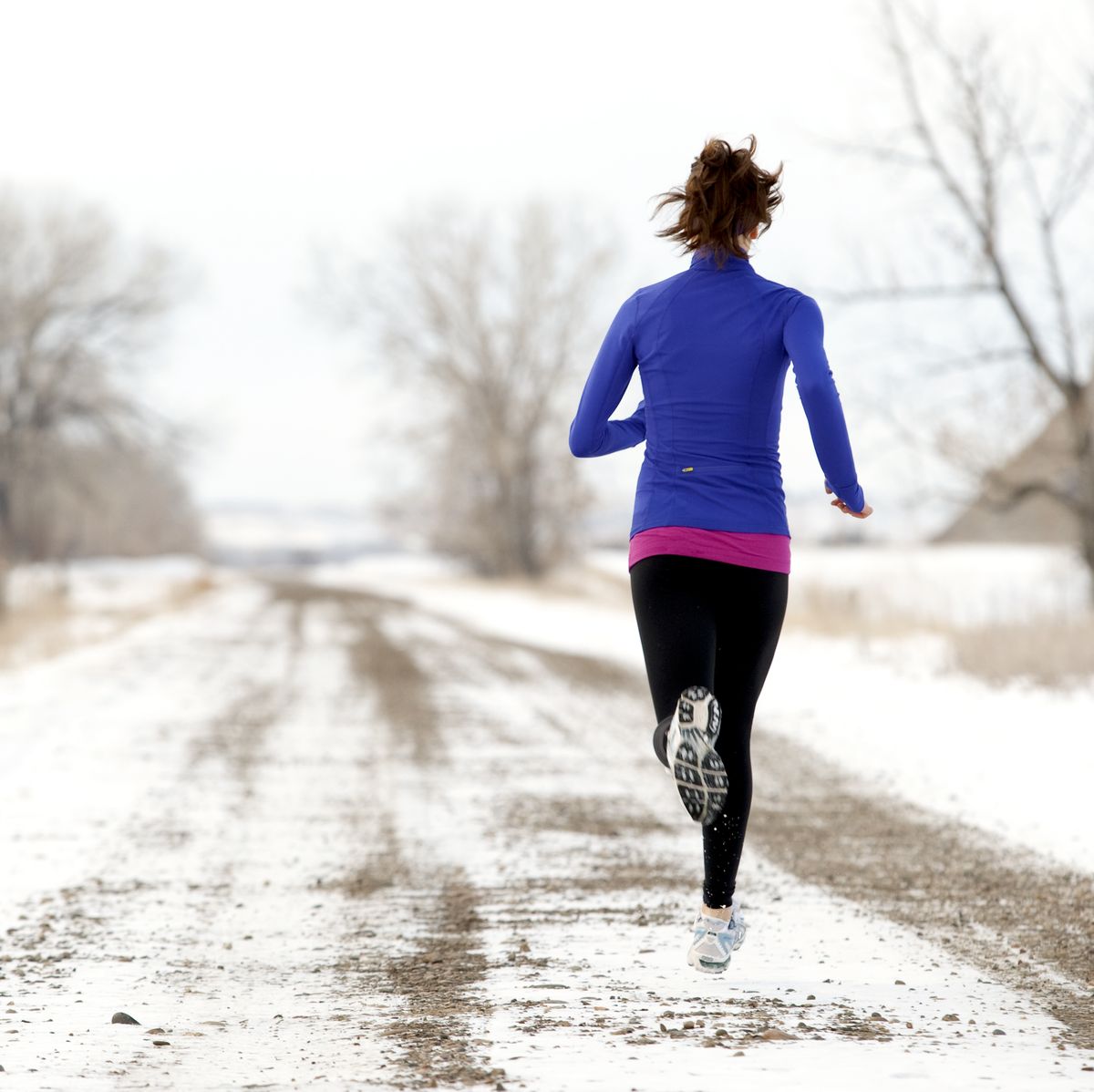 an athletic woman jogging in the winter fasted cardio