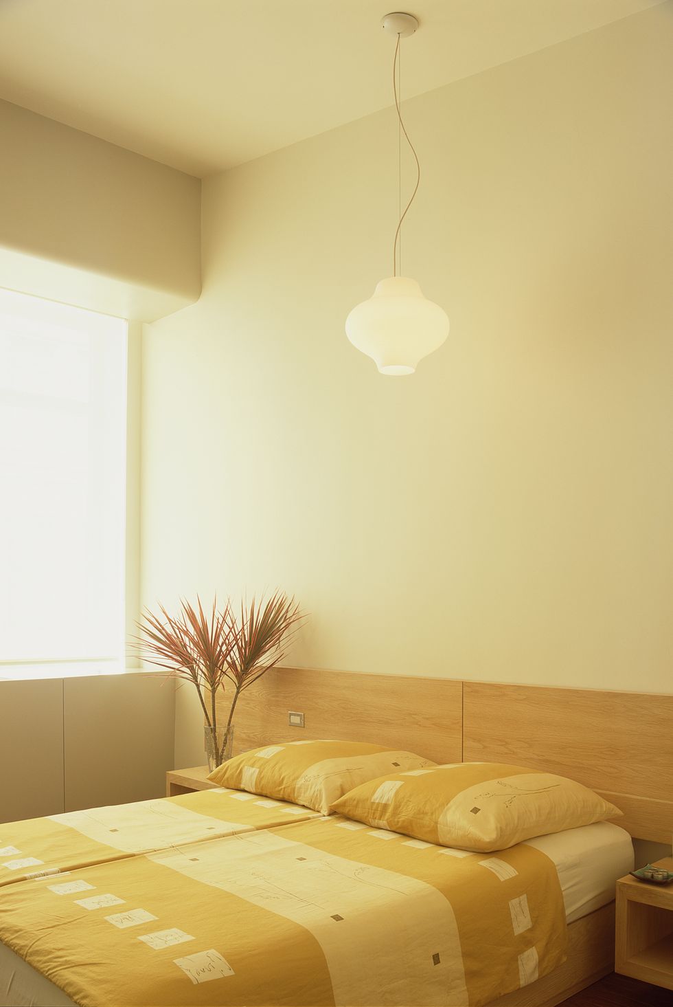 an elegant lamp is suspended from the ceiling above the bed in the bedroom
