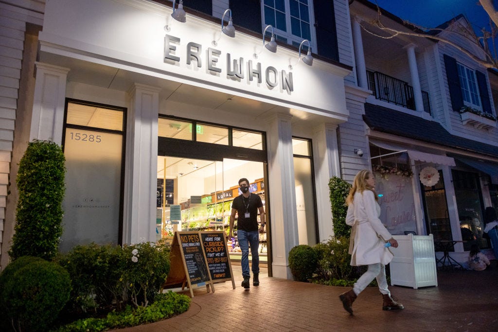 https://hips.hearstapps.com/hmg-prod/images/an-employee-wearing-a-mask-walks-out-of-an-erewhon-store-in-news-photo-1697832833.jpg?crop=0.5625xw:1xh;center,top&resize=1200:*