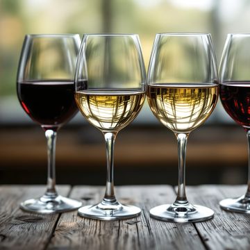an image of four wine glasses on a wooden surface