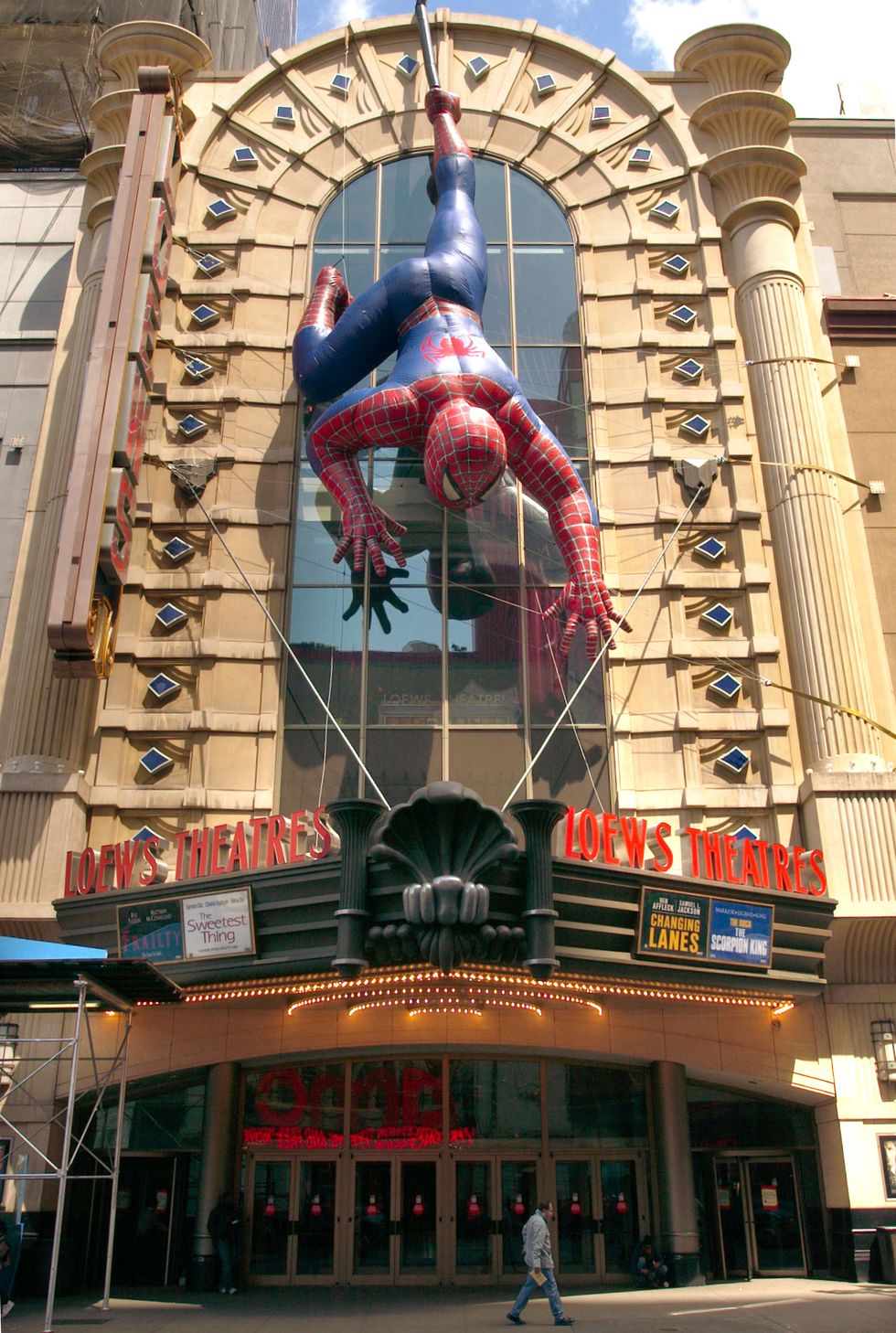 inflatable spiderman hangs on movie theatre