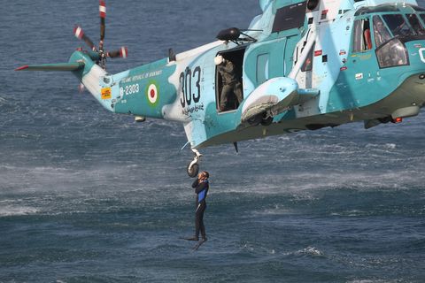 an iranian navy diver jumps out of a hel