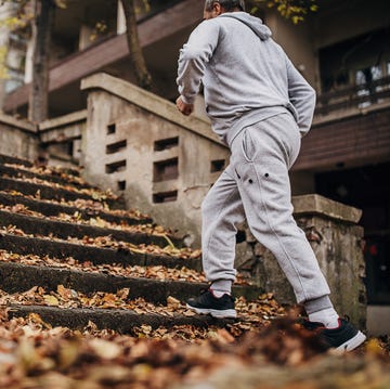 An older man exercises on the steps with autumn leaves an older man exercises on the steps with autumn leaves