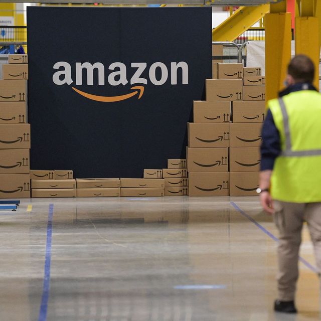 an amazon employee passes by its logo on the opening day of the new distribution center in augny, eastern france, on september 23, 2021