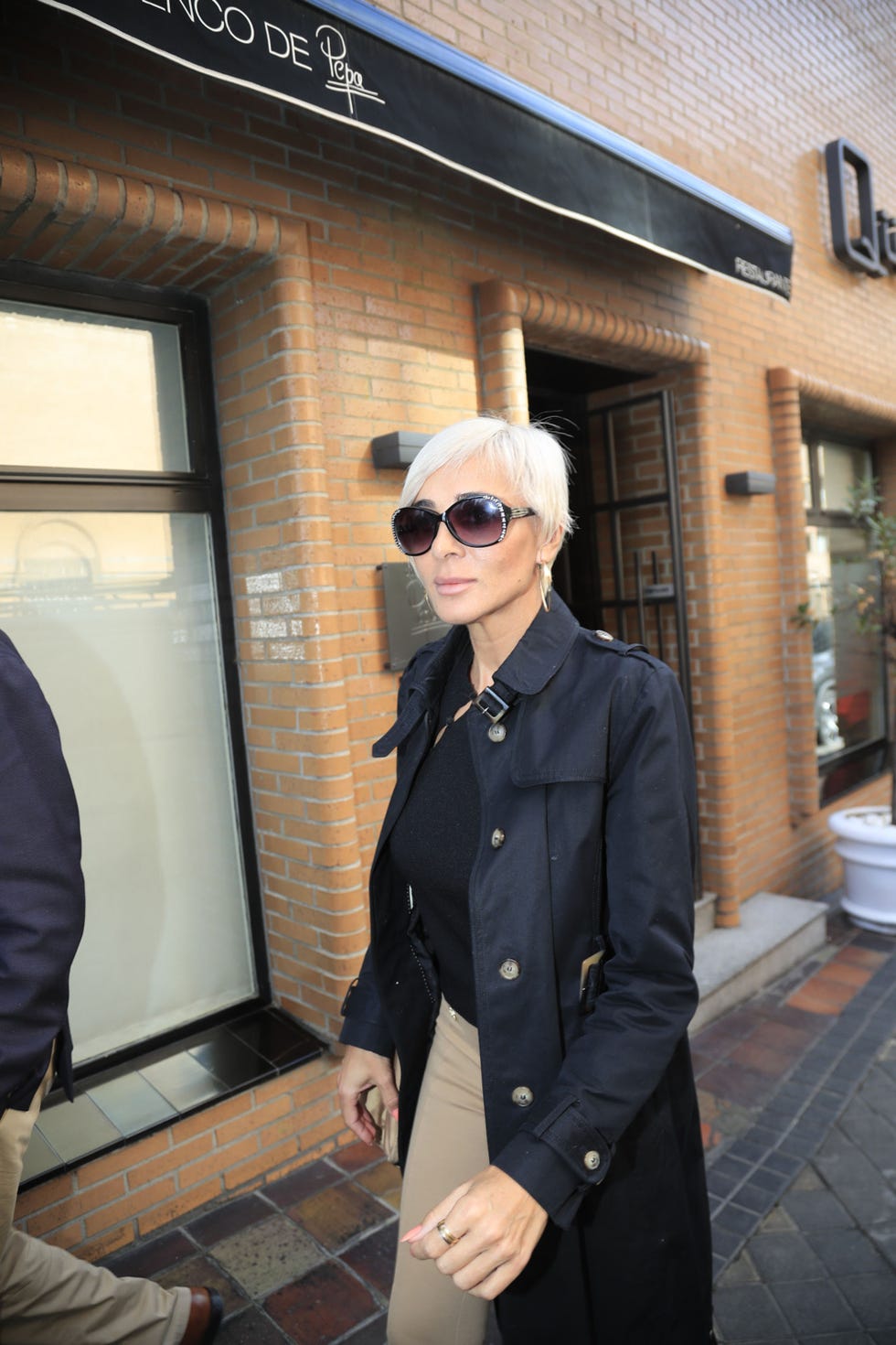 la diseñadora, con gafas de sol, sale de un restaurante de madrid