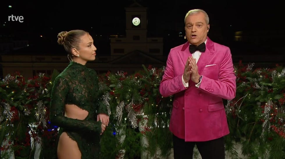 a man and a woman standing next to a christmas tree