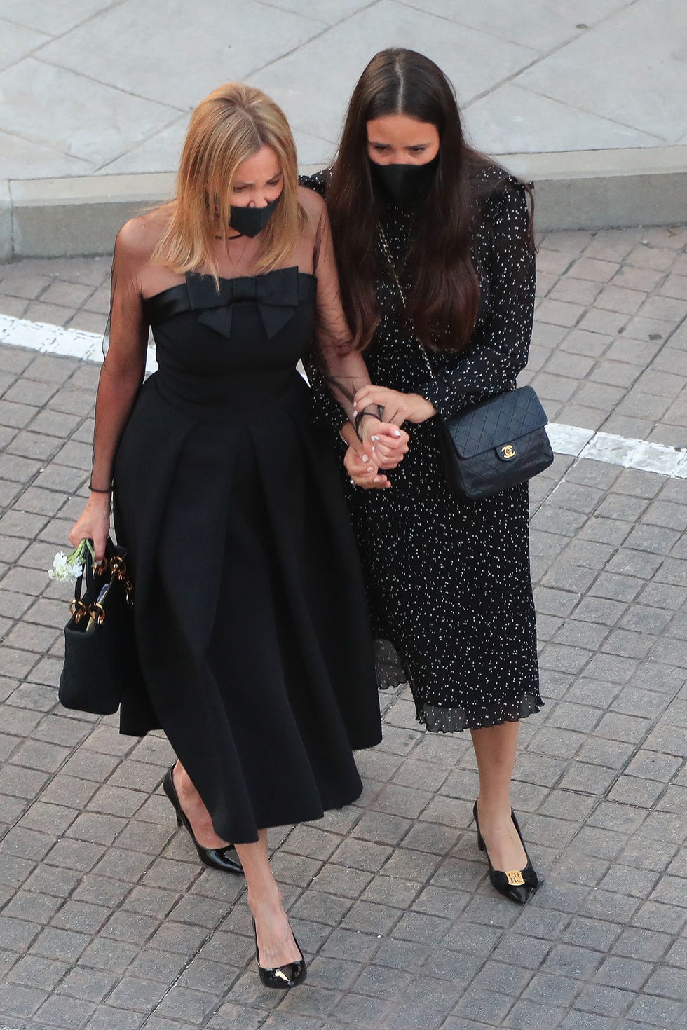 ana obregón y carolina monje caminan agarradas de la mano a la salida del funeral de aless lequio