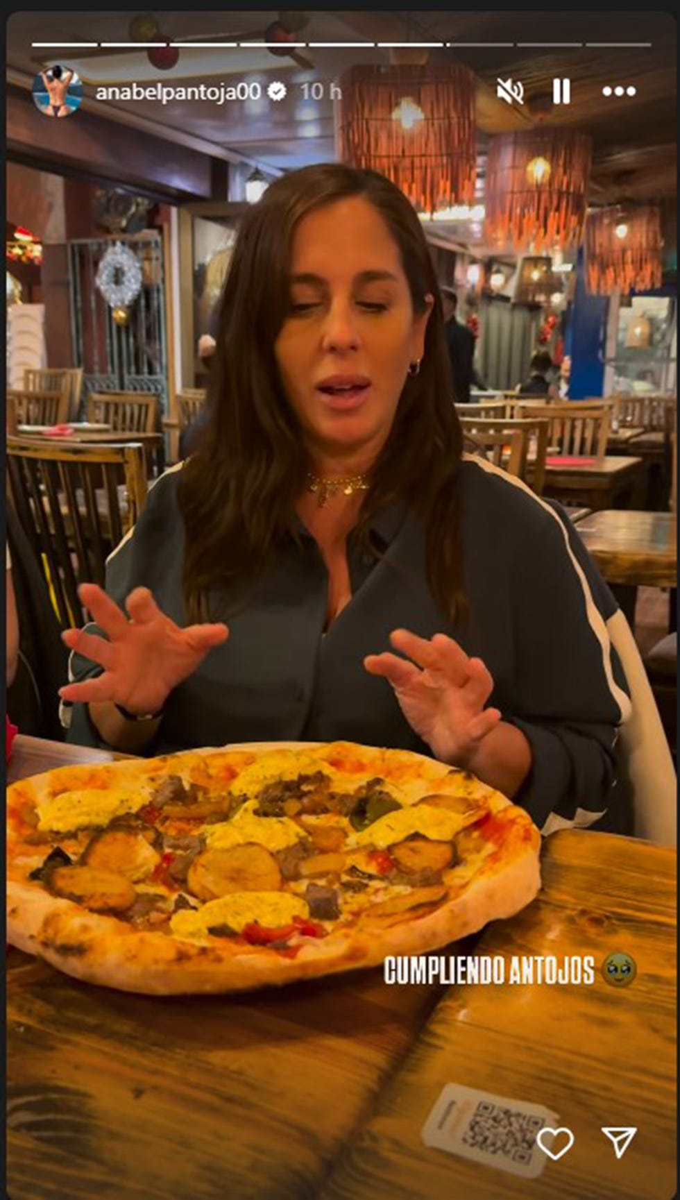 anabel pantoja con una pizza en un restaurante
