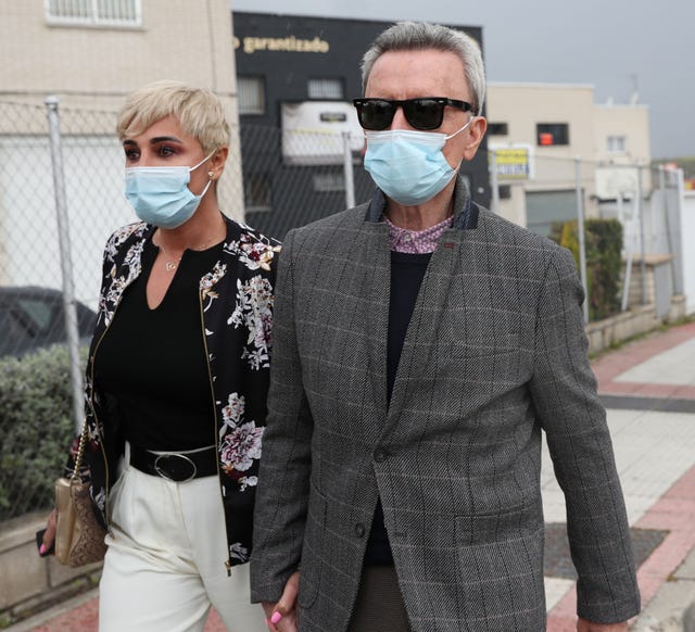 la pareja, cogida de la mano y con mascarilla