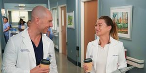 richard flood y ellen pompeo, como el doctor hayes y la doctora grey, se sonríen tomando un café por los pasillos del hospital de anatomía de grey