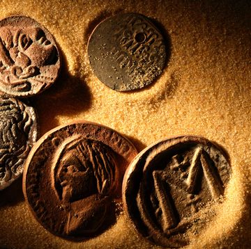 ancient coins laying in golden sand