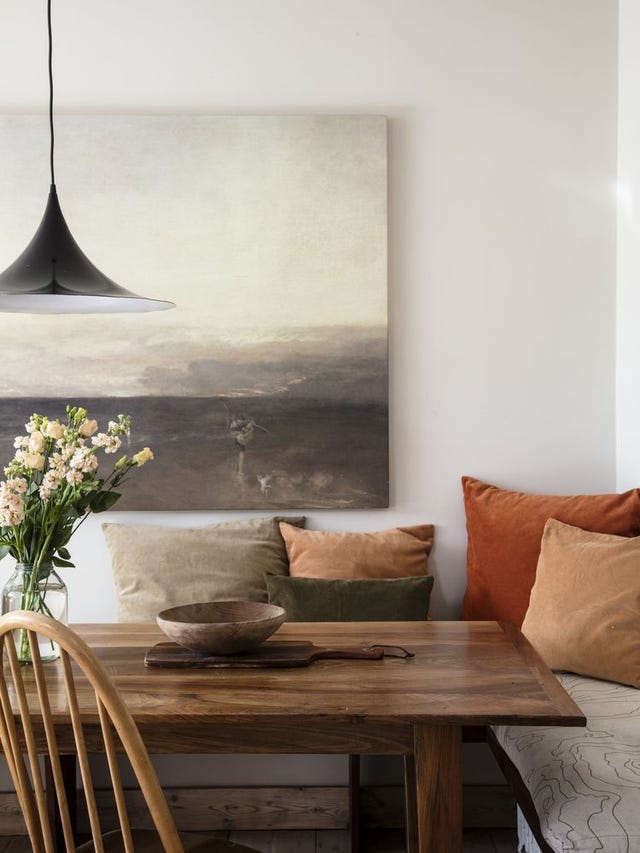 Dining area with walnut table, bench seating with cushions and 1960s pendant light