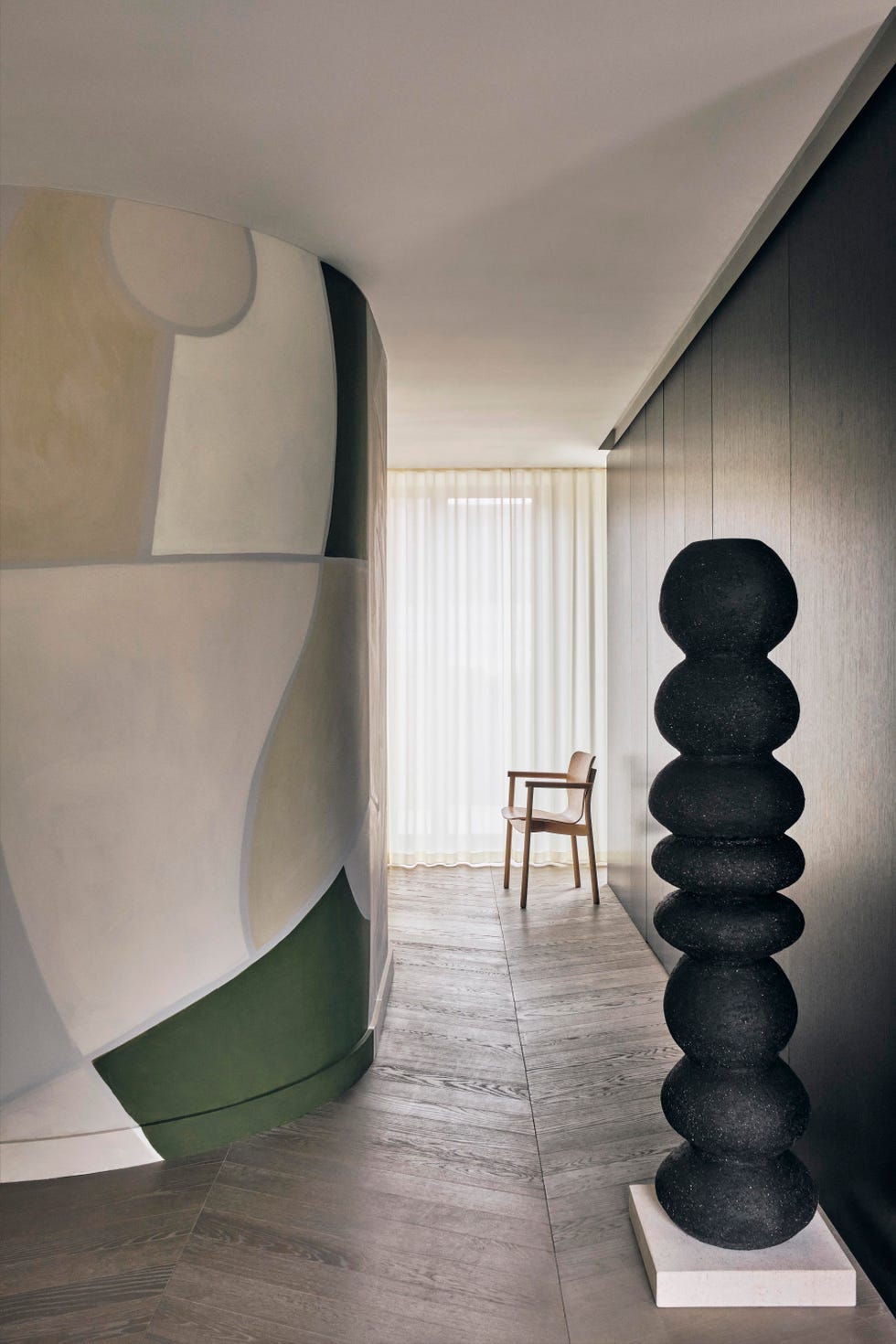 minimalist hallway with graphic wall mural and black sculpture