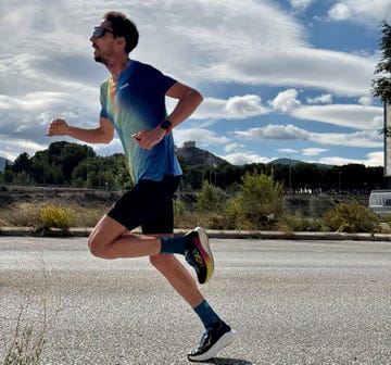 a person running on a road with a castle in the background