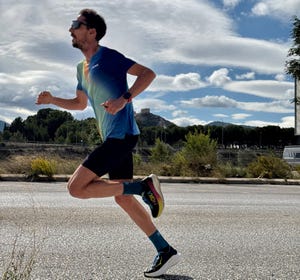 a person running on a road with a castle in the background