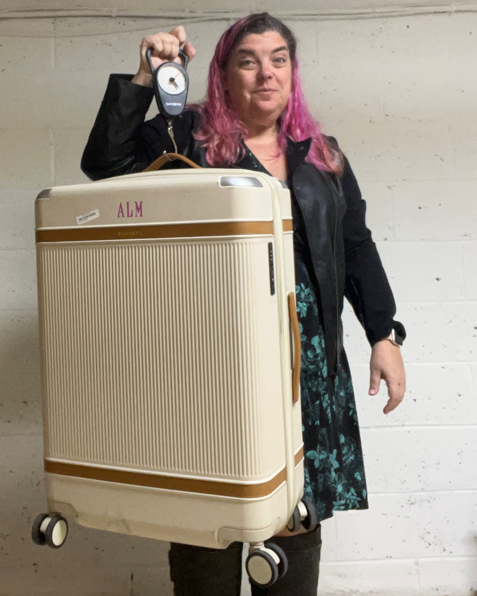 person holding a suitcase with a scale