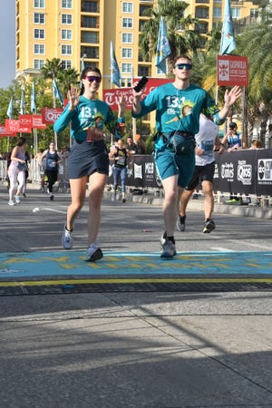 angela burgess and james whelan finishing the 2023 gasparilla half marathon