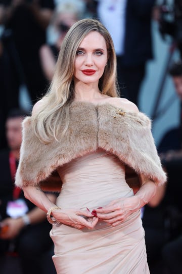 angelina jolie poses in beige gown with a fur stole