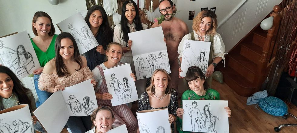 a group of people holding up drawings