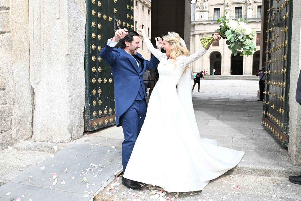 couple celebrating their wedding outside a grand entrance