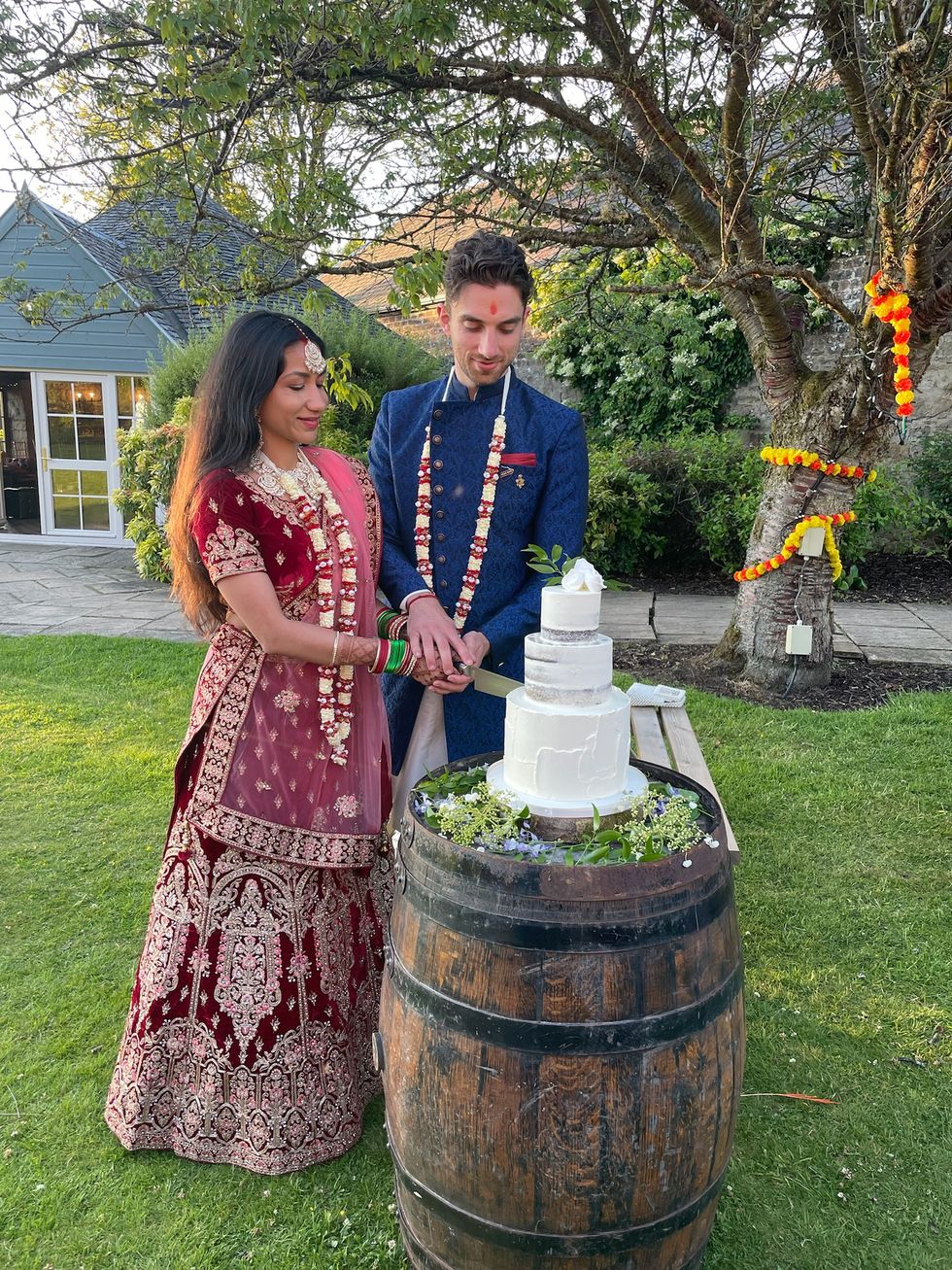 a man and woman standing next to a barrel with a white object on it