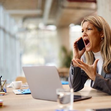 angry businesswoman talking on mobile phone in the office.