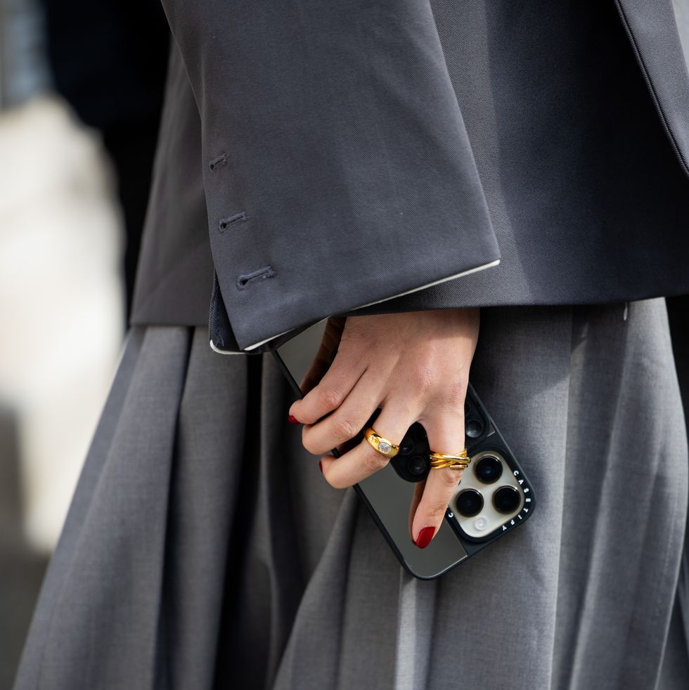 new york, new york february 12 a guest wears grey blazer, pleated skirt with slit, iphone case, rings outside coach on february 12, 2024 in new york city photo by christian vieriggetty images
