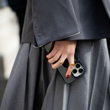 new york, new york february 12 a guest wears grey blazer, pleated skirt with slit, iphone case, rings outside coach on february 12, 2024 in new york city photo by christian vieriggetty images