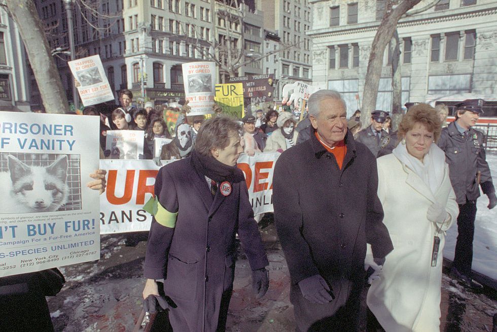 bob barker leading a crowd of people in new york city, many of whom carry animal rights signs