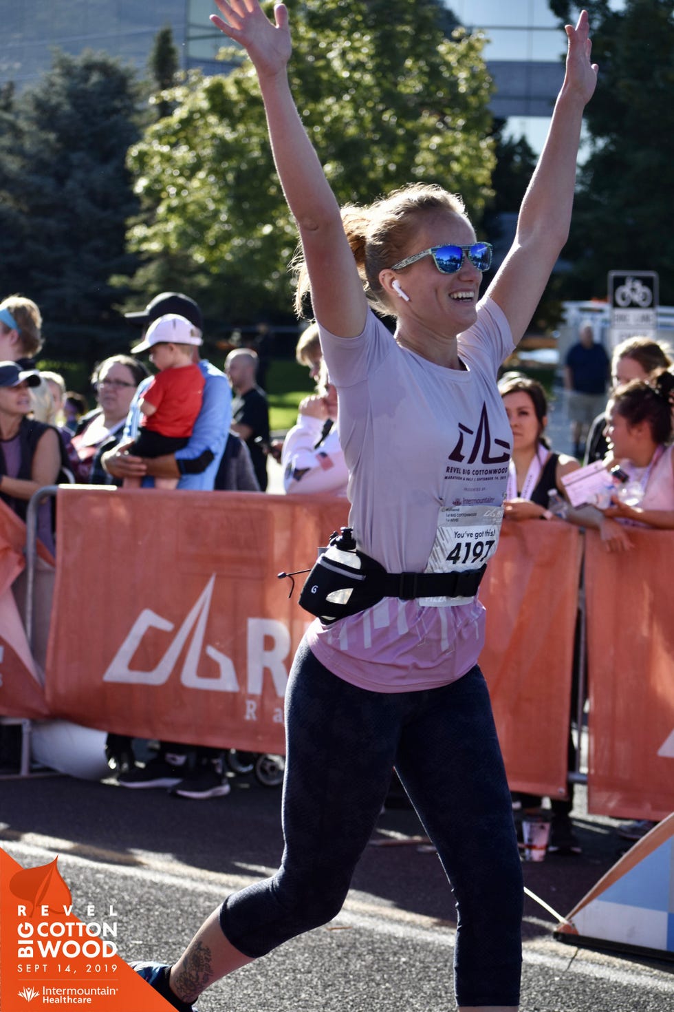 a person in a white shirt and sunglasses with the arms up