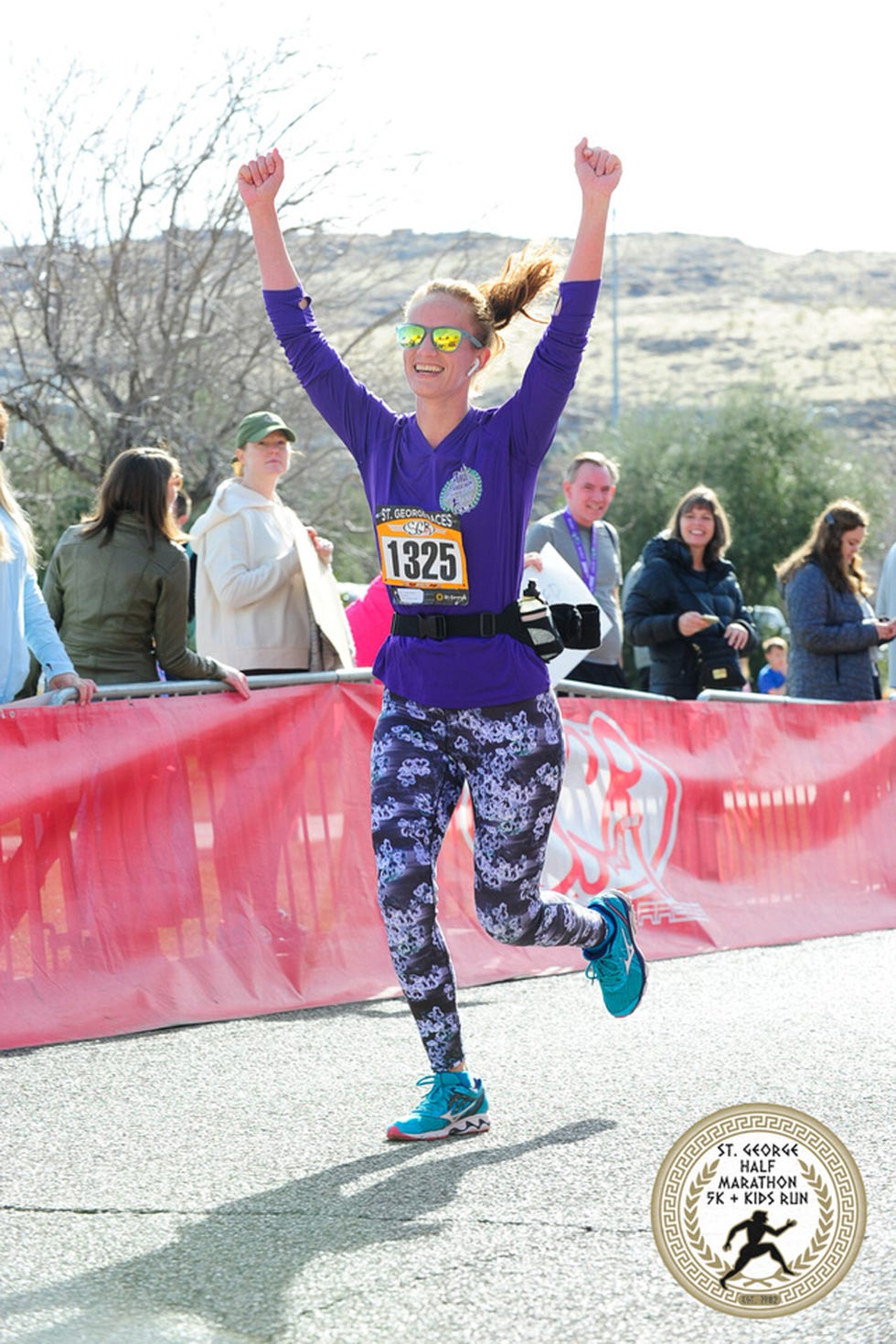 a woman running on a road with people watching