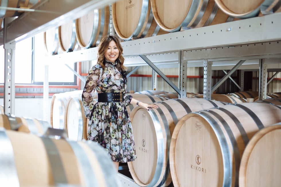 kikori whiskey founder ann soh woods standing in front of barrels