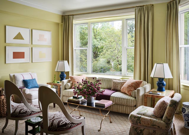 anna brockway chairish new york apartment living room with chartreuse walls, couch, lamps on end tables