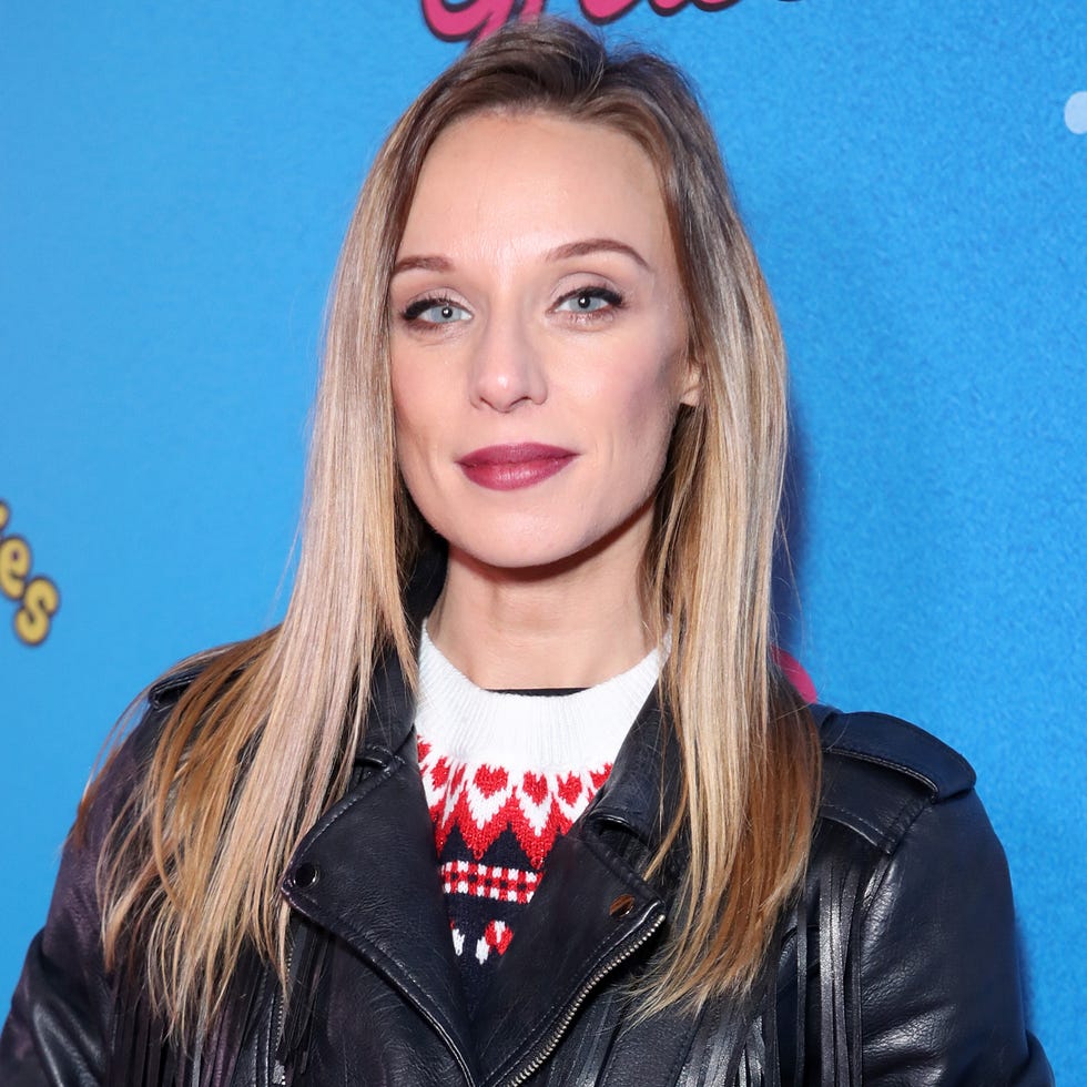 anna nightingale wearing a red leather skirt and black biker jacket