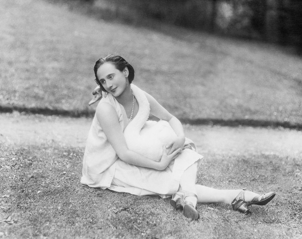 original caption anna pavlova 1885 1931, russian ballet dancer, shown with one of her pet swans, wrapped around her, which inspired her famous dance "death of the swan" undated photograph