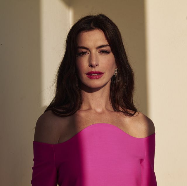 anne hathaway wears hot pink and poses against wall