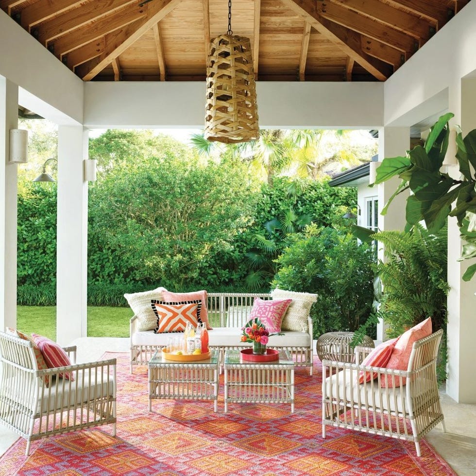 a patio with white chairs and a table with a red and white table and a white and red a patio with white chairs and a table with a red and white table and a white and red