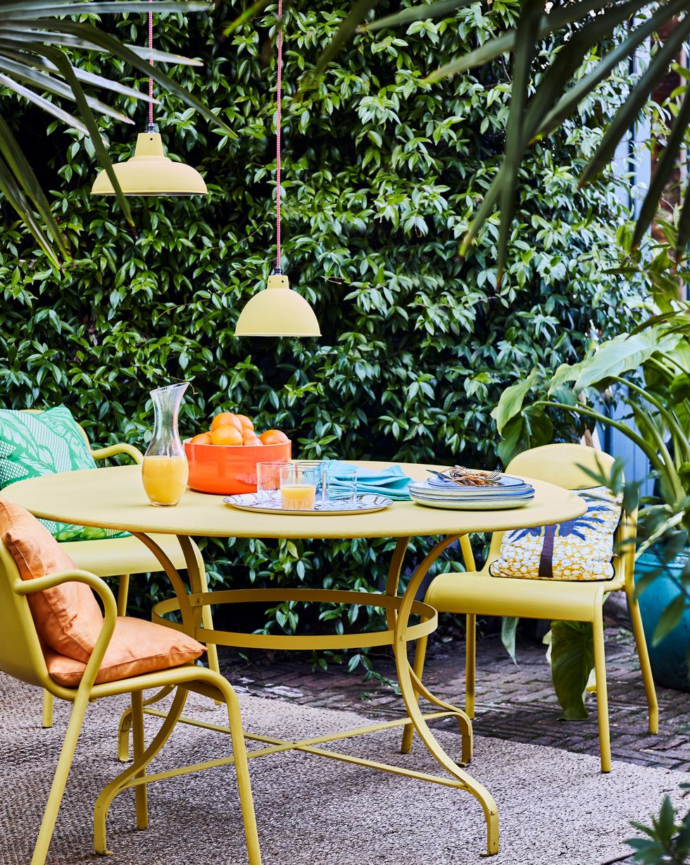 Furniture, Table, Patio, Outdoor table, Outdoor furniture, Chair, Yellow, Room, Leisure, Tree, 