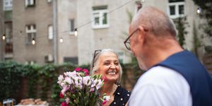 anniversary captions woman smiling to man and holding a bouquet of flowers