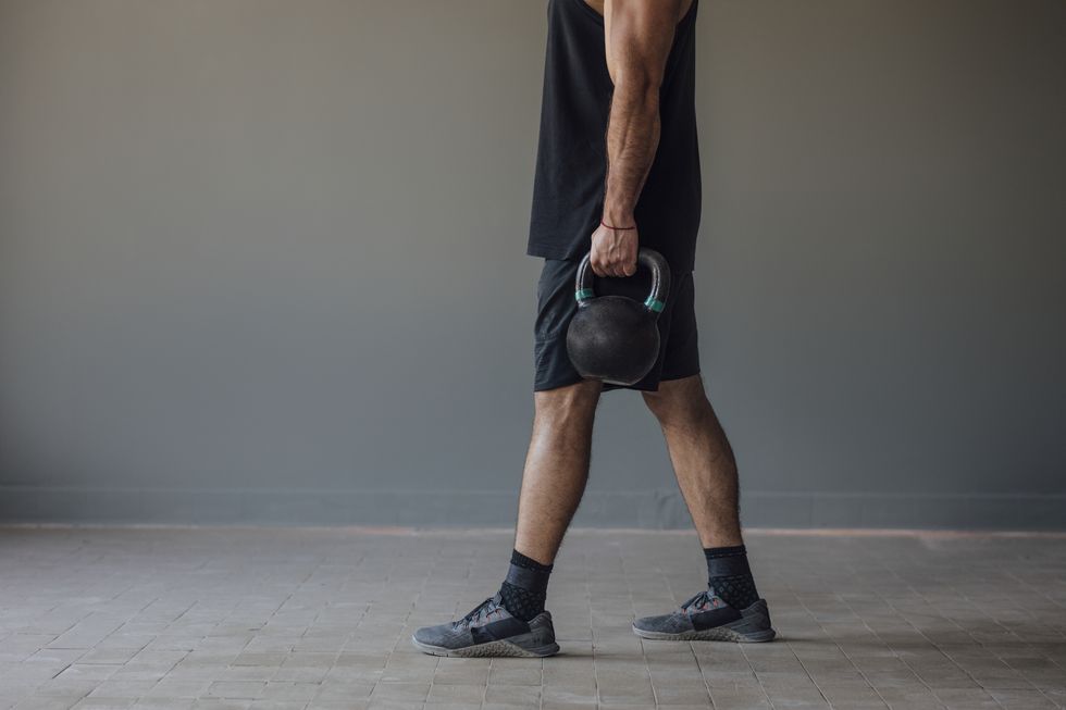 anonymous man exercising with kettlebells, cross training concept