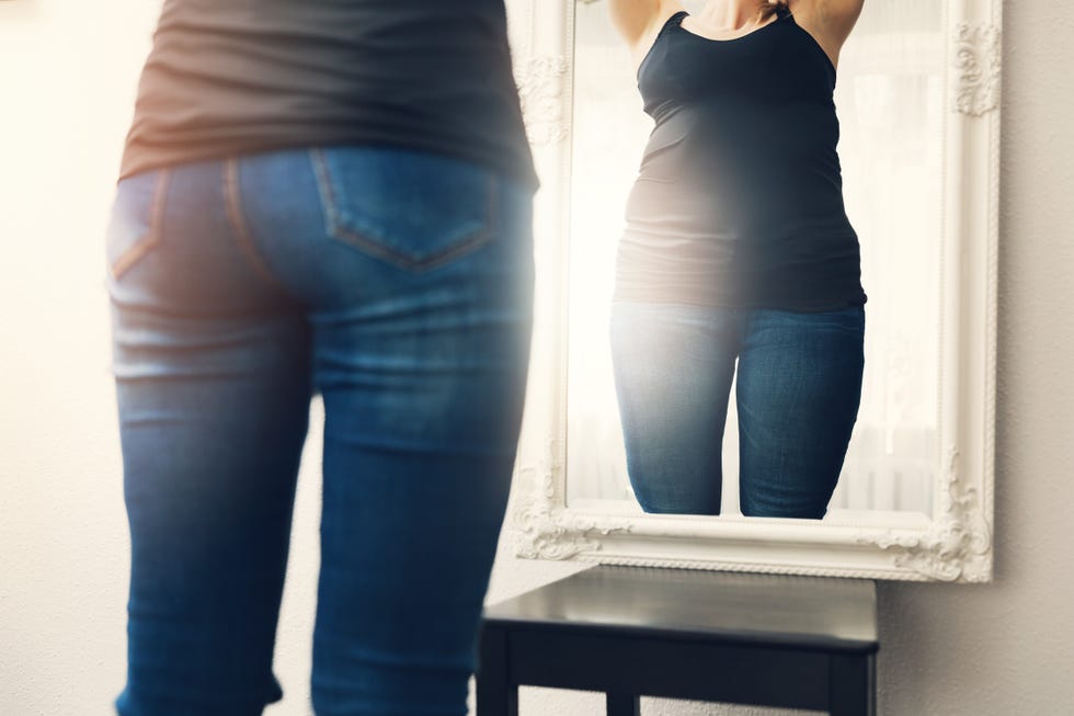 fat woman in blue jeans isolated on white background. Diet concept