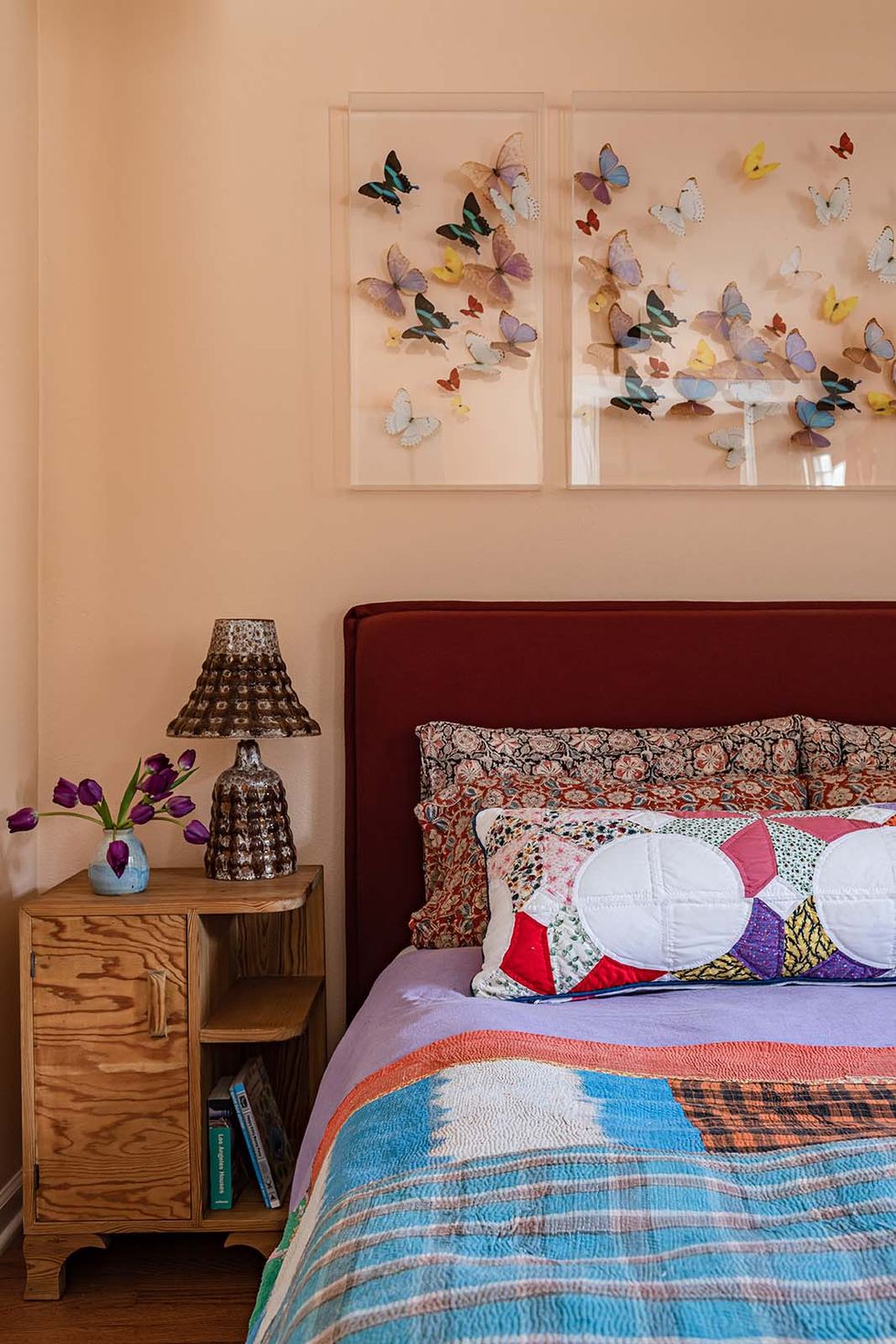 primary bedroom with butterfly art and quilted pillows