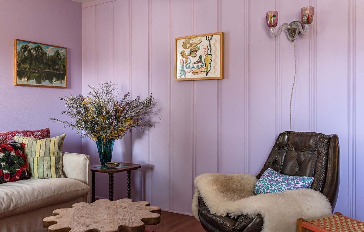 purple living room with leather chair and wall art