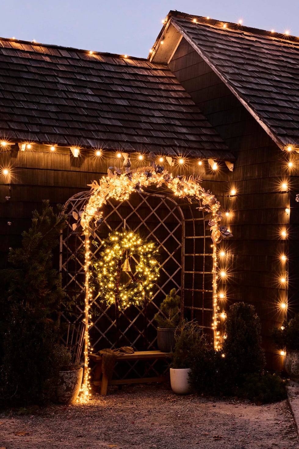 Decoratively lit entrance decoratively lit entrance with a wreath and bench, next to wooden house siding